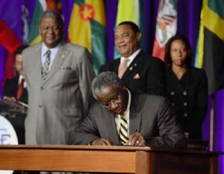 Prime Minister Freundel Stuart signing the “Treaty of Chaguaramas” yesterday. (Trinidad Express photo) 