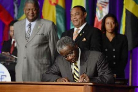 Prime Minister Freundel Stuart signing the “Treaty of Chaguaramas” yesterday. (Trinidad Express photo)