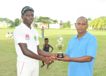 Man of the match Steven Sankar receives his trophy from GCB’s Chairman of the Junior Selection panel, Nazimul Drepaul 