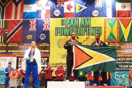 Randolph Morgan (centre) and Anis Ade Thomas holding the Golden Arrowhead yesterday after finishing first and second respectively in the 83kgs Men class of the Caribbean Powerlifting Championships. 