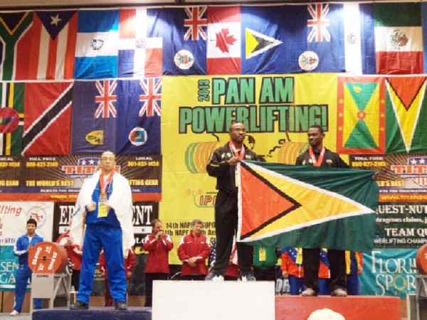 Randolph Morgan (centre) and Anis Ade Thomas holding the Golden Arrowhead yesterday after finishing first and second respectively in the 83kgs Men class of the Caribbean Powerlifting Championships. 