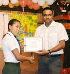 Sylvia Alexander, of Region 9 receives her certificate from Ministry of Amerindian Affairs’ Permanent Secretary Nigel Dharamlall at the Hinterland Scholarship Programme graduation at the Amerindian Village, Sophia on Wednesday. (Government Information Agency photo)