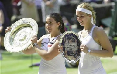 Marion Bartoli of France (L) holds her trophy, the Venus Rosewater Dish, after defeating Sabine Lisicki of Germany (R) in their women’s singles final tennis match at the Wimbledon Tennis Championships, in London July 6, 2013. (Reuters/Toby Melville).