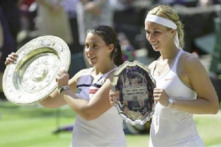 Marion Bartoli of France (L) holds her trophy, the Venus Rosewater Dish, after defeating Sabine Lisicki of Germany (R) in their women’s singles final tennis match at the Wimbledon Tennis Championships, in London July 6, 2013. (Reuters/Toby Melville).