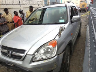 Cecil Gajadhar’s vehicle in the passageway between Republic Bank and GTM yesterday morning. A bullet hole is visible in the windscreen. 