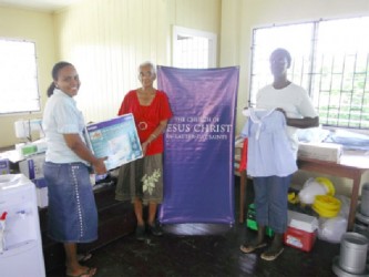 From left: Marcia McKenzie, Eugene Lewis and Mrs Young, a community member with some the donated items 