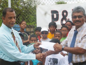 Managing Director of P and P Insurance Brokers and Consultants Limited Bish Panday (left) handing over sponsorship cheque to GLTA President Ramesh Seebarran while camp participants look on