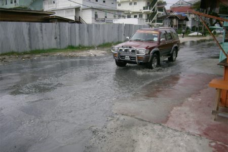 A vehicle manoeuvres through the effluent caused by the burst sewerage line at the corner of Hadfield and Smyth streets yesterday afternoon. 