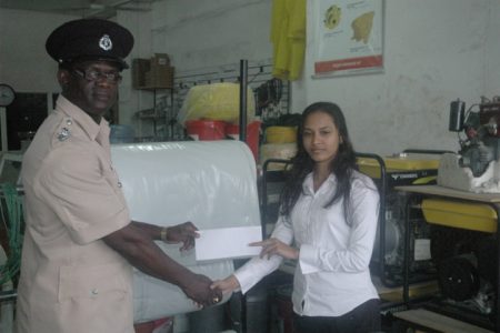 K&B Mining and Hardware Supplies Accountant Seeta Husain (right) presents the sponsorship cheque to Police Sports Officer, Deputy Superintendent of Police Colin Boyce yesterday.
