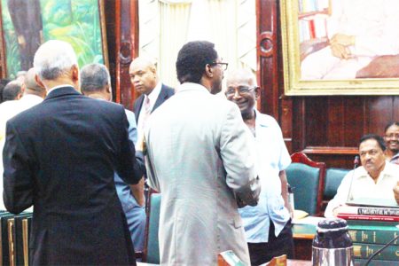 APNU MPs Ronald Bulkan (left) and Basil Williams engage Local Government Minister Ganga Persaud during the 10-minute parliamentary recess yesterday.
