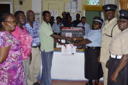 In photo, Chairman of the WSMC, Emile Wilson (left in background) presenting the generator to Corporal Avella David in the presence of other officers and members of the WSMC.