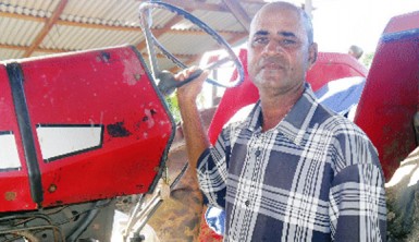 Mohamed Baksh stands next to his tractor.