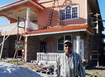 Odit Narine Singh in front of the modern house he is constructing