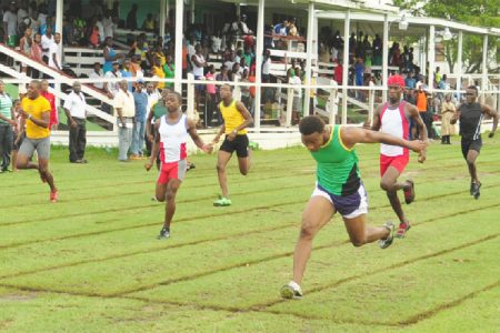 Kevin Abbensetts (right) dips at the 100m finish line in the Youth Club boys’ 100m heats yesterday afternoon ahead of sprint sensation Tevin Garraway (second left). (Orlando Charles photo)