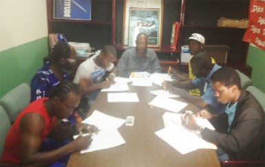 It’s official! Clive ‘The Punisher’ Atwell (right) affixes his signature to his contract to make his ring date with Shurwyne ‘The Mauler’ Marshall become a reality. Other boxers signing their contracts yesterday were (from left) Richard Williamson, Howard ‘Battersea Bomber’ Eastman, Laured Stewart, Anson Green and Mark Austin.