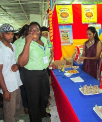 A patron of the Berbice Expo and Trade Fair enjoying one of the samples from the Namilco booth (Photo by David Papannah)