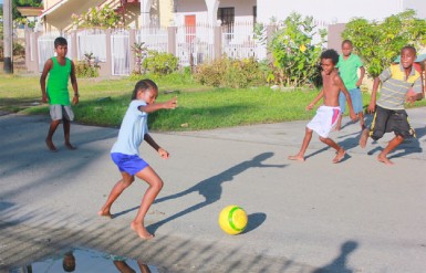 Street football: Channelling Zinedine Zidane or Diego Maradona? These young boys were enjoying a game of football in Marigold Street, West Ruimveldt yesterday (Photo by Arian Browne)