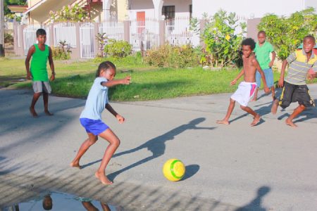 Street football: Channelling Zinedine Zidane or Diego Maradona? These young boys were enjoying a game of football in Marigold Street, West Ruimveldt yesterday (Photo by Arian Browne)