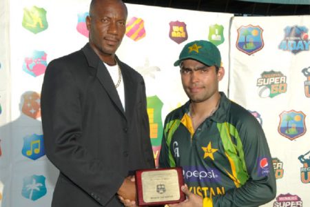 Umar Akmal receives his Man-of-the –Match award from former West Indies fast bowler Nixon Mc Lean. (photo courtesy WICB media)