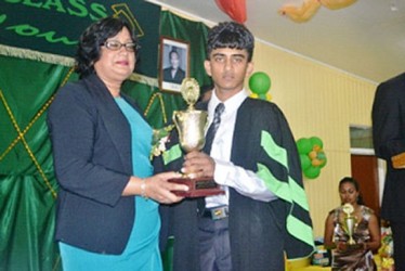 Lalita Baksh presents a trophy to Vishan Persaud from the Mon Repos campus. (GINA photo) 