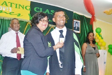 Alwyn Seegolam receives his gold medal from  Lalita Baksh. He attained a Distinction in the Diploma in Agriculture programme at the Essequibo campus. (GINA photo)