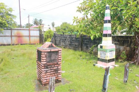 Two monuments standing in the compound of the Victoria Culture Centre; the larger of the two is in honour of the 83 former slaves who bought the village and whose names it records. (Arian Browne photo)