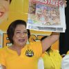 Prime Minister Kamla Persad-Bissessar holds up a copy of yesterday’s Express during the United National Congress’ (UNC) Monday night forum last night at the Warrenville Regional Complex in Cunupia. 