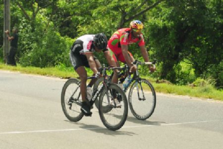 Robin Persaud edges Warren ‘40’ McKay to take yesterday’s 10th annual Regan Rodrigues 50-mile road race on the West Demerara. (Orlando Charles photo)