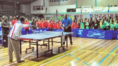 Juan Villa President of the Caribbean Regional Table Tennis Federation (left) and Minister of Culture, Youth and Sport, Dr. Frank Anthony, officially declares the championships open with the traditional serve off. (Orlando Charles photo)   