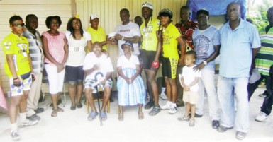 Roberts receives his reward from Rawle Felix while 96-year-old Grenville Felix and 94-year-old Rachel Michael among other family members savour the moment.   