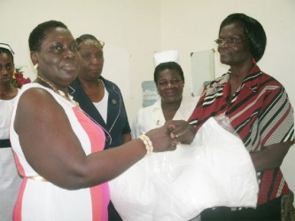 National Psychiatric Hospital Administrator Leila Clark-Daniels (right) accepts the donation from Joan Fields