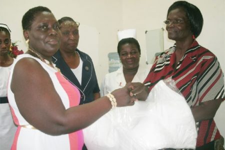 National Psychiatric Hospital Administrator Leila Clark-Daniels (right) accepts the donation from Joan Fields