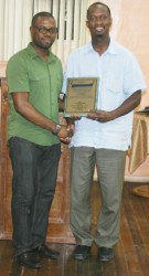 Dr. Stephen Carryl (right) receives a plaque of appreciation for his annual mission to Linden from Region Ten Chairman Sharma Solomon