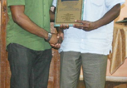 Dr. Stephen Carryl (right) receives a plaque of appreciation for his annual mission to Linden from Region Ten Chairman Sharma Solomon