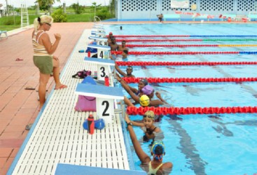 Head Coach Isabella Couso Fals pays keen attention to the swimmers during their final training session at the National Aquatic Centre yesterday afternoon. (Orlando Charles photo)