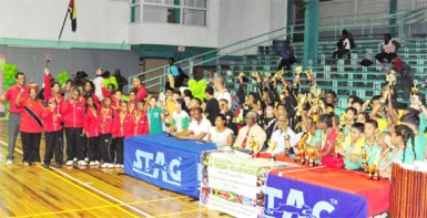 From left GTTA President Godfrey Munroe, GT&T Brand Manager Nicola Duggan, Administrator of the National Sports Commission, Gervy Harry, Director of Sports Neil Kumar and Caribbean Regional Table Tennis association President Juan Villa, surrounded by the teams from some of the participating countries. 