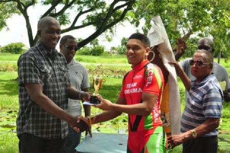 Alanzo Greaves receiving his winner’s trophy from Banks DIH Brand Manager of Malta Supreme, Clayton McKenzie. (Orlando Charles photo)