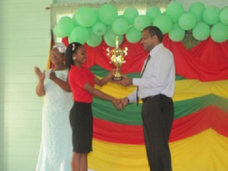 Minister of Culture, Youth and Sports Dr. Frank Anthony presents the Most Outstanding student Keisha Ajudia with an award (GINA photo)