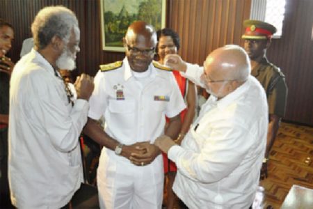 Commander- in- Chief of the Armed Forces, President Donald Ramotar (right), and Secretary of the Defence Board, Dr. Roger Luncheon pinning the insignia of the rank of Rear Admiral on Guyana Defence Force Chief  of  Staff Gary Best. (GINA photo)