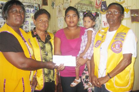 NA Lions Club President, Georgina Hoosley (left) presenting the cheque to Melissa Chase in the presence of other Lions members 