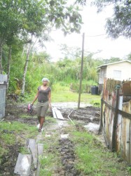 Jonell Van-Doimen making her way out of her yard (her house is in the background) by using the passageway of another person’s land. 