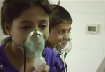 Children, affected by what activists say was a gas attack, breathe through oxygen masks in the Damascus suburb of Saqba, August 21, 2013. REUTERS/Bassam Khabieh 