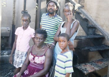 Seretse and Felicia George with their children in the burnt-out house 