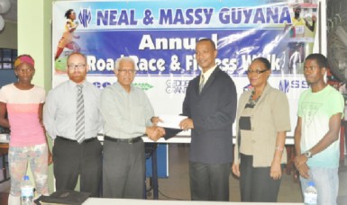 CEO of Neal and Massy, Deo Persaud (third from left) presents the sponsorship cheque to president of the AAG, Aubrey Hutson following the launch of yesterday’s fourth annual N&M Guyana 10k Road Race and Fitness Walk. (Orlando Charles photo) 