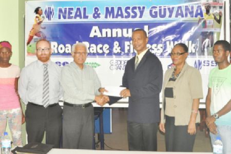CEO of Neal and Massy, Deo Persaud (third from left) presents the sponsorship cheque to president of the AAG, Aubrey Hutson following the launch of yesterday’s fourth annual N&M Guyana 10k Road Race and Fitness Walk. (Orlando Charles photo)
