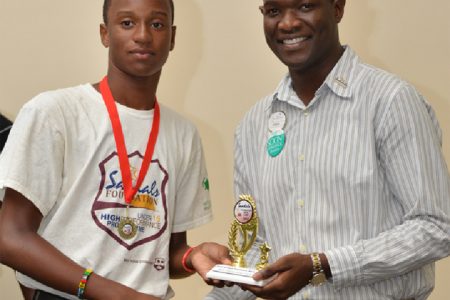 Renaldo Mohammed receives his trophy from Sandals Foundation representative OBrian Heron - WICB Media photo
