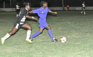 Action between the Georgetown (left) and Berbice female football teams Wednesday night at the GFC ground. (Orlando Charles photo) 