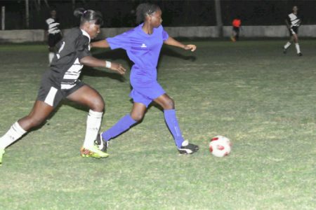 Action between the Georgetown (left) and Berbice female football teams Wednesday night at the GFC ground. (Orlando Charles photo)