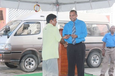 Telford Taylor, Lokono artist of St Cuthbert’s Mission, presents a model fish to Culture Minister Dr Frank Anthony at the launch of Heritage Month yesterday at the Ministry of Culture. (Photo by Arian Browne) 