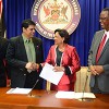 Prime Minister Kamla Persad-Bissessar shakes hands with Legal Affairs Minister Prakash Ramadhar at yesterday’s post Cabinet news conference at the Prime Minister’s office in St Clair yesterday. Looking on is Labour Minister Errol McLeod, right, and Minister of Tobago Development, Delmon Baker